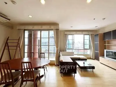 Spacious living room with city view, modern furniture, and natural light.