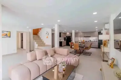 Spacious open-plan living room with modern furniture and elegant dining area, perfect for entertaining.