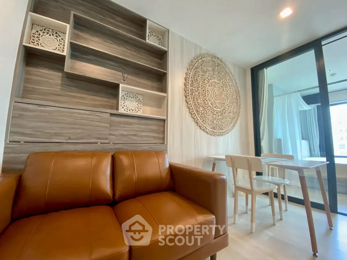 Stylish modern living room with leather sofa and artistic wall decor in a cozy apartment.