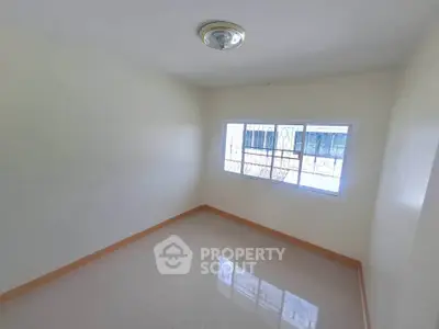 Bright empty room with large window and tiled floor, perfect for customization.