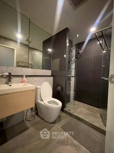 Modern bathroom with sleek design, glass shower, and elegant fixtures.