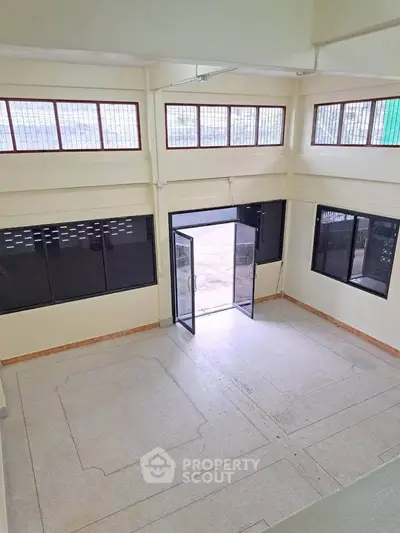 Spacious commercial space with large windows and double glass doors, ideal for business setup.