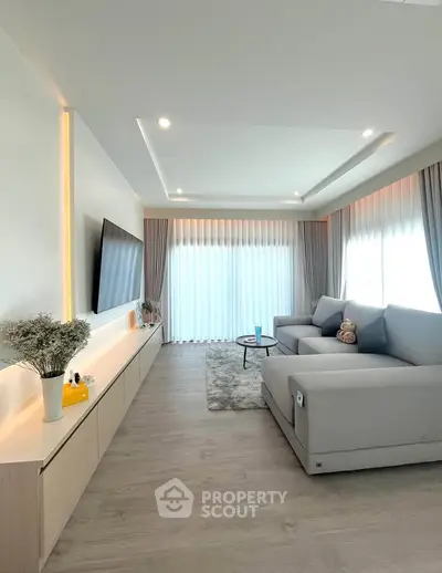 Modern living room with sleek design, large sofa, and natural light.