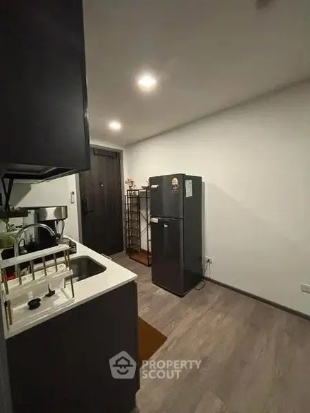 Modern kitchen with sleek black fridge and compact design