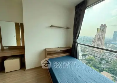 Modern bedroom with large window offering stunning city view in high-rise apartment.