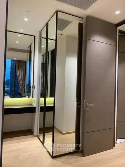 Modern bedroom with mirrored closet doors and city view window