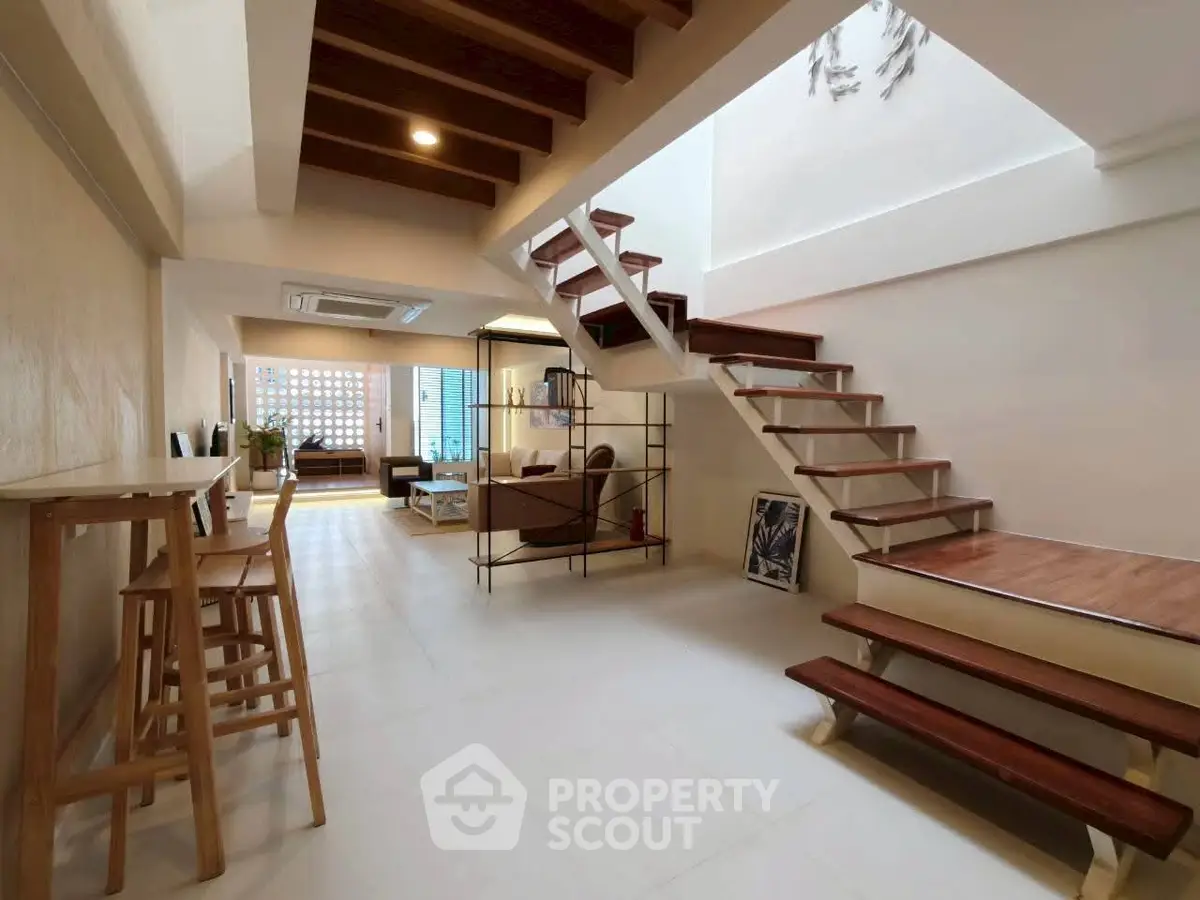 Spacious modern living room with stylish staircase and open layout, perfect for contemporary living.
