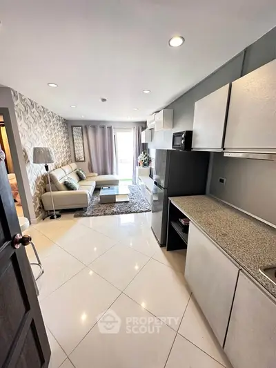 Modern open-layout living room with sleek kitchen and stylish decor in a contemporary apartment.