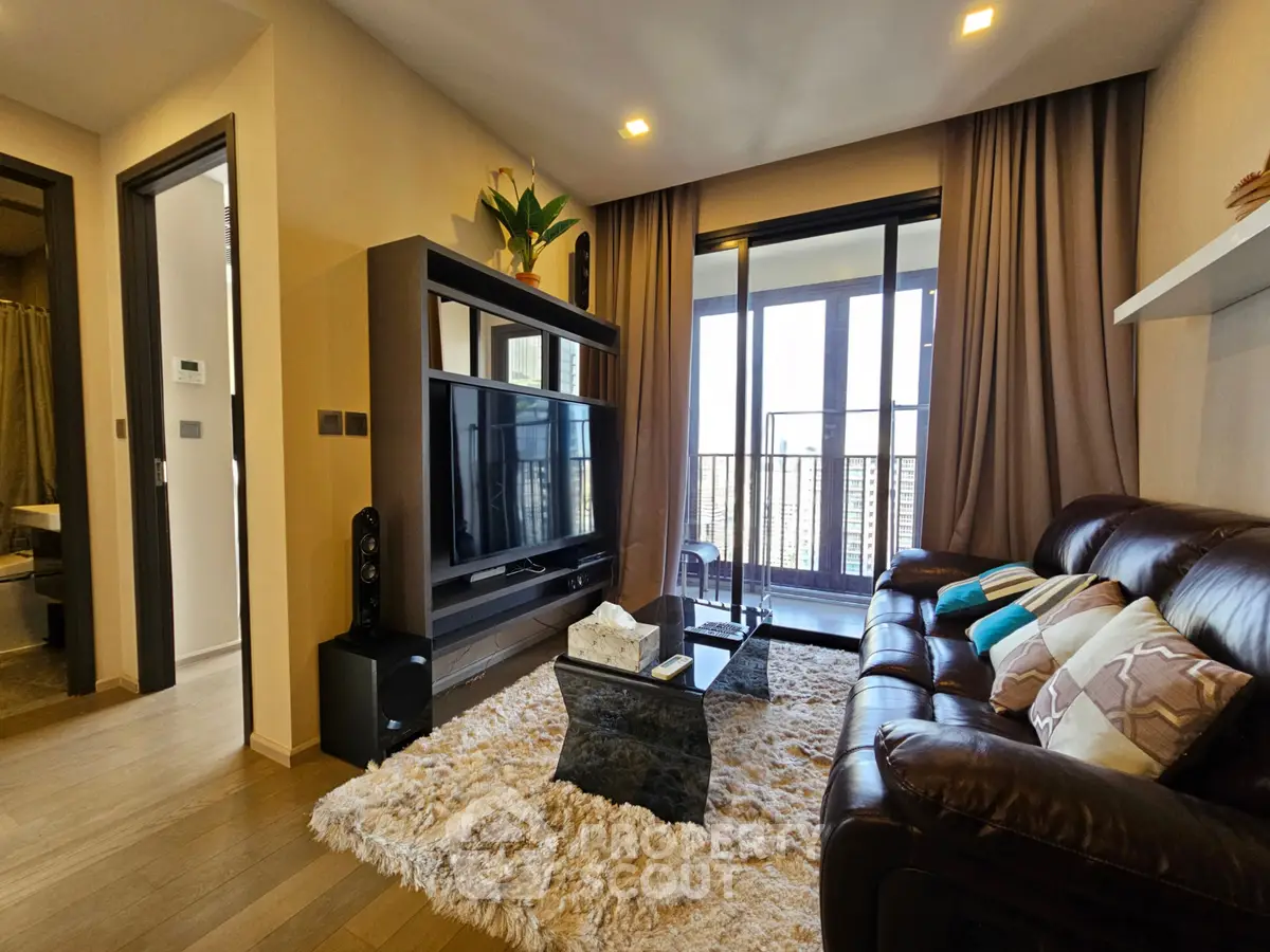 Luxurious living room with plush leather sofa, modern entertainment center, and floor-to-ceiling windows leading to balcony.