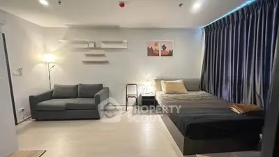 Modern studio apartment with cozy bed, stylish sofa, and ambient lighting.