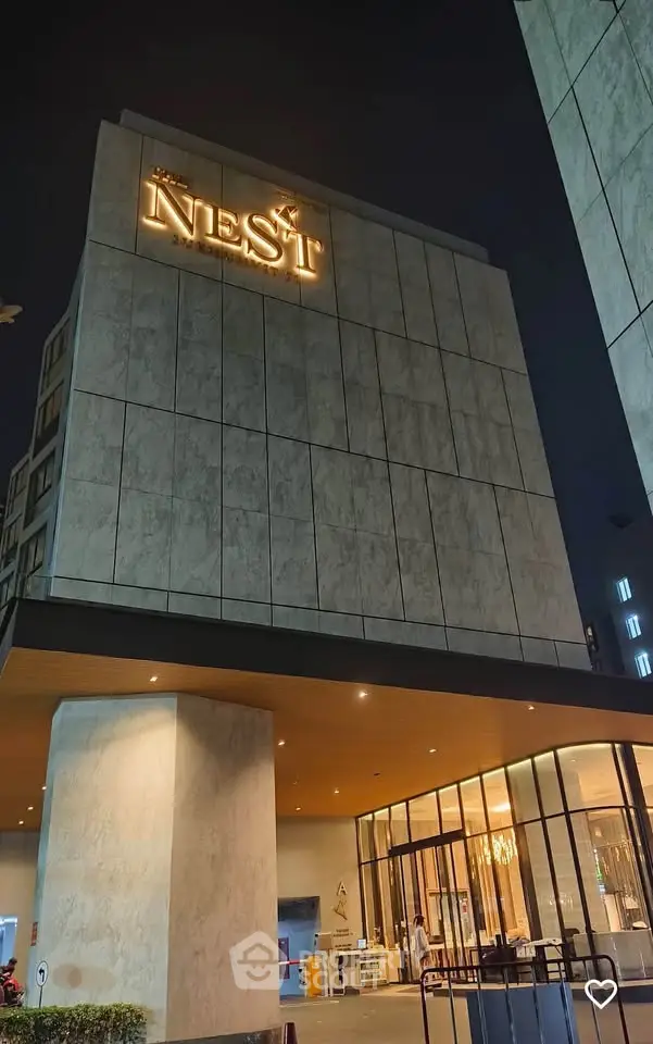 Modern building entrance with elegant lighting and sleek architectural design at night.
