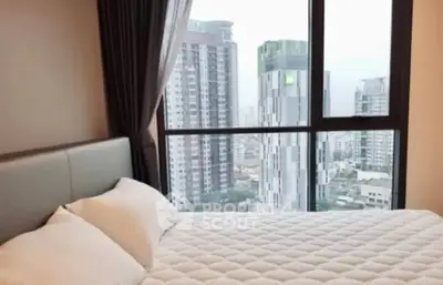 Modern bedroom with city view from large window in high-rise apartment