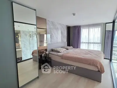 Modern bedroom with large windows and stylish decor in a high-rise apartment.