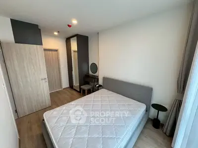 Spacious bedroom with modern furnishings and natural light in a stylish apartment.