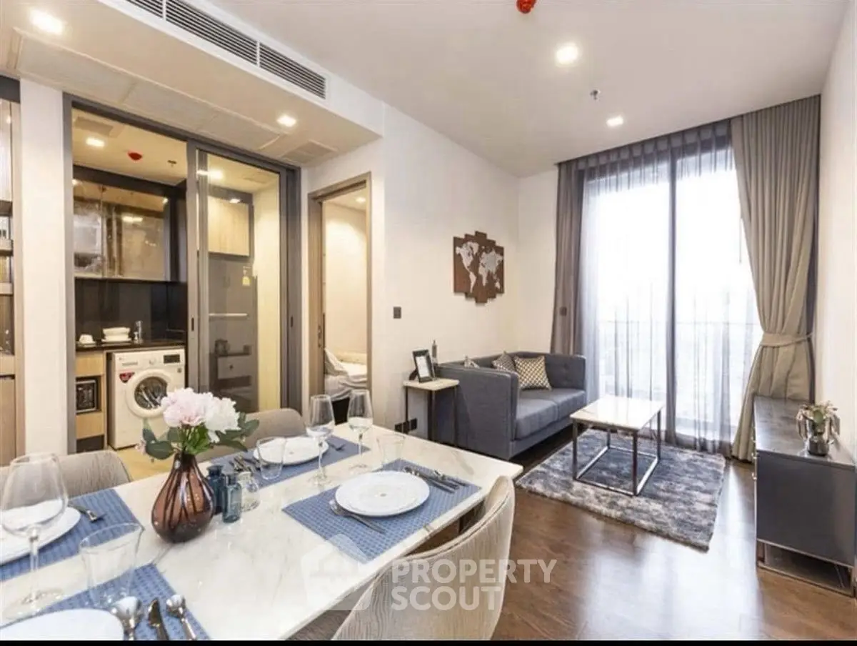 Modern living room with dining area and balcony access in stylish apartment.