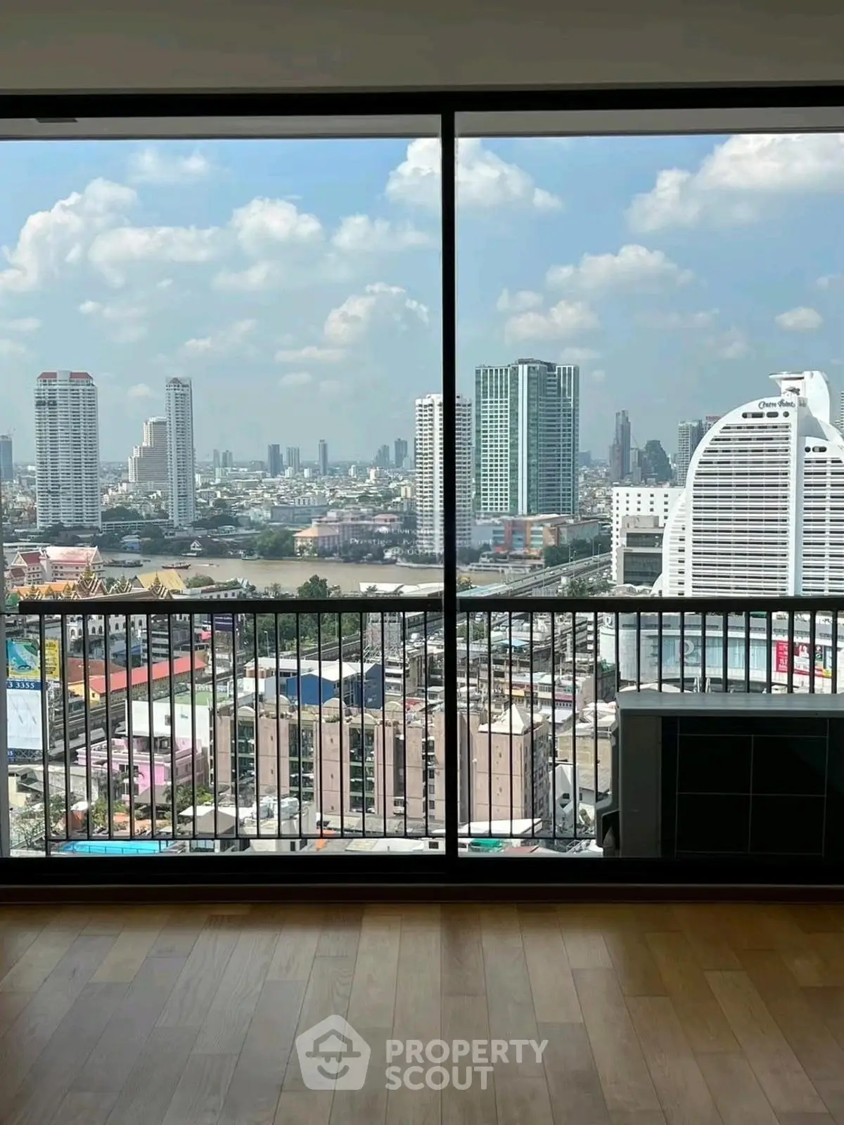 Stunning cityscape view from a high-rise apartment with floor-to-ceiling windows.