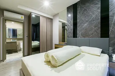 Elegant bedroom with modern design, featuring a large bed, sleek wood accents, and a connected en-suite bathroom.