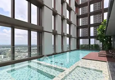 Luxurious rooftop pool with stunning city views in a modern high-rise building.