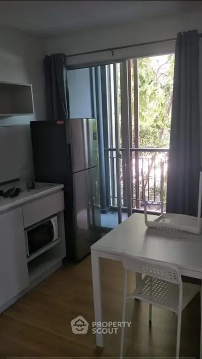Modern kitchen with fridge and balcony view in a stylish apartment