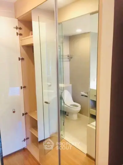 Modern bathroom with glass partition and wooden storage shelves