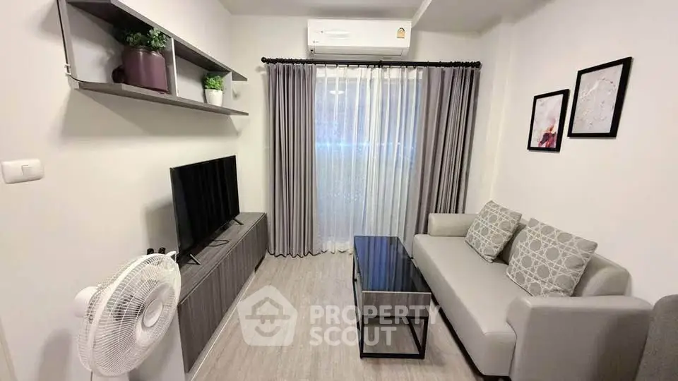 Modern living room with sleek furniture and stylish decor, featuring a cozy sofa and entertainment unit.
