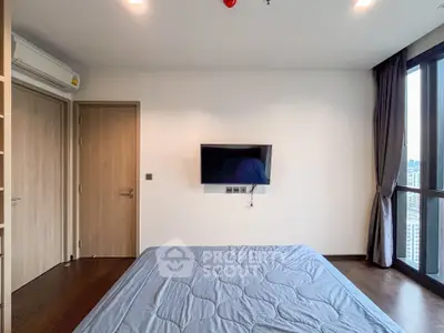 Modern bedroom with wall-mounted TV and large window offering city view.