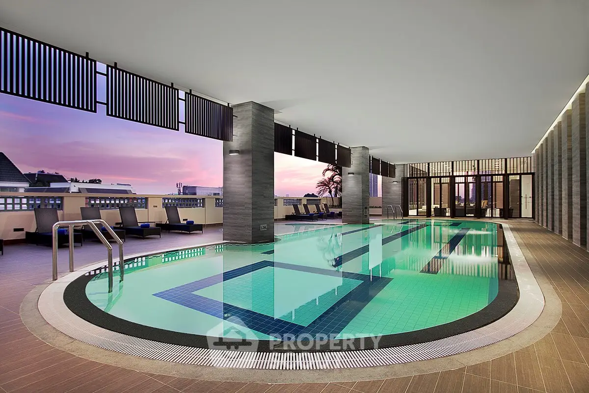 Luxurious indoor pool with stunning sunset view, perfect for relaxation and leisure in a modern residential complex.
