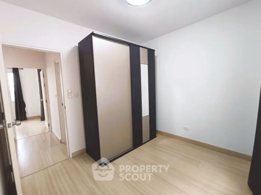Spacious bedroom with sleek wardrobe and wooden flooring