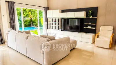 Spacious living room with modern furniture and pool view, perfect for relaxation and entertainment.