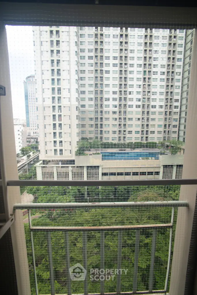 High-rise apartment view with lush greenery and cityscape backdrop