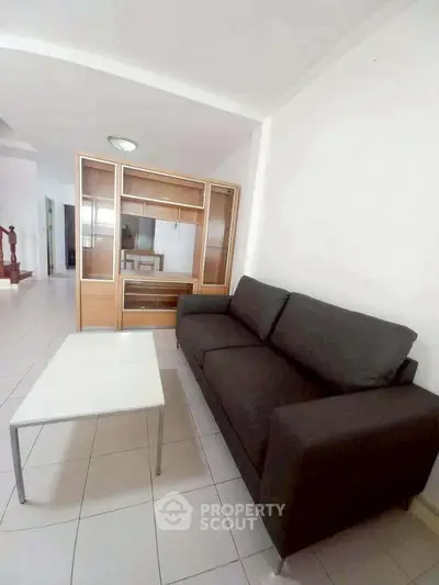 Spacious living room with modern sofa and sleek coffee table in a bright apartment.