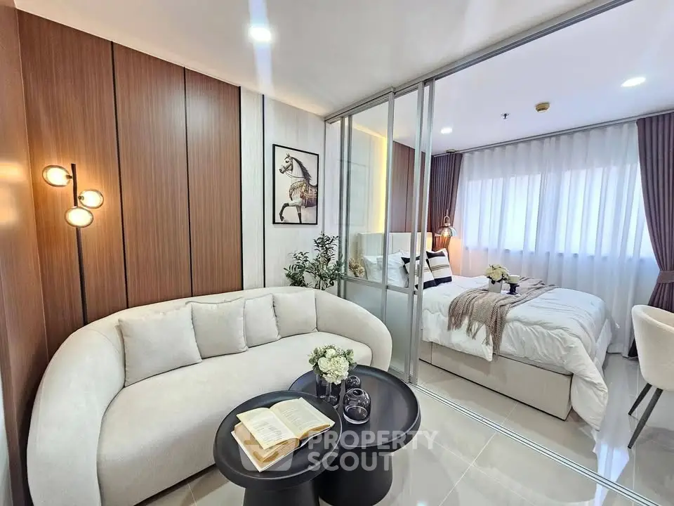 Modern living room with cozy sofa and elegant bedroom in open layout apartment.