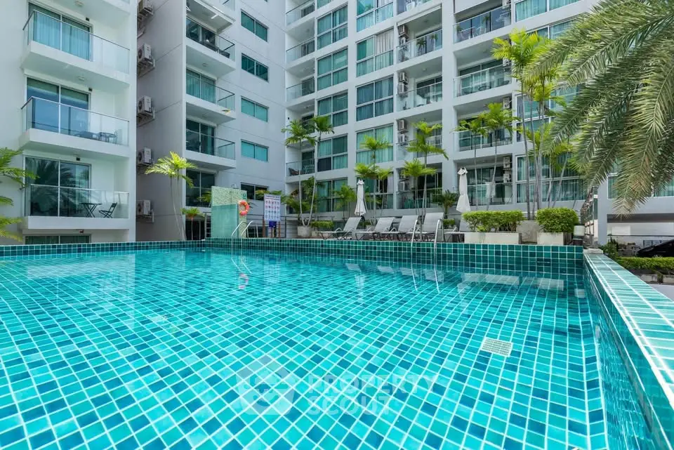Luxurious condominium with a sparkling pool and lush greenery, perfect for relaxation and leisure.
