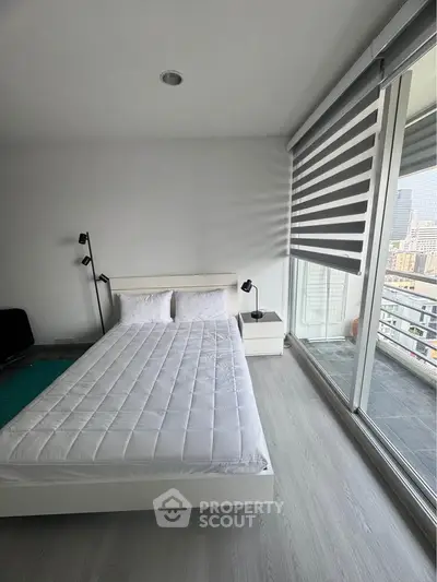 Modern bedroom with large windows and city view, featuring sleek design and ample natural light.