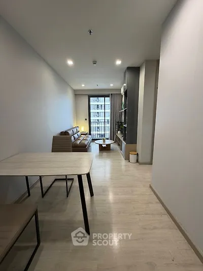 Modern living room with sleek furniture and balcony view in a stylish apartment.