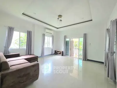 Spacious living room with modern design and large windows offering natural light and scenic views.