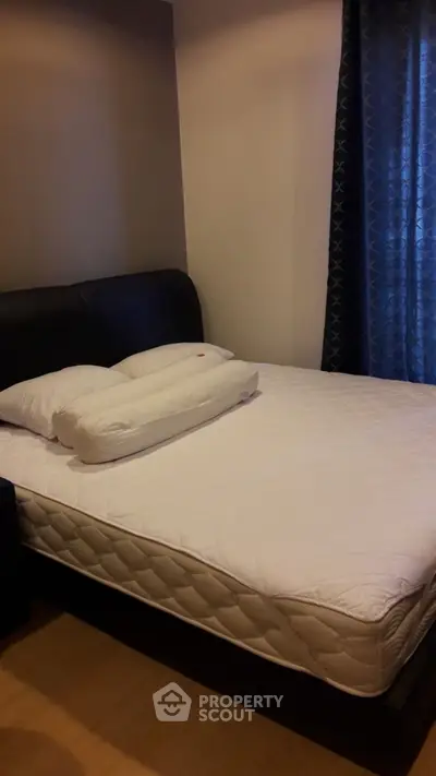 Cozy bedroom with a comfortable bed and elegant curtains, perfect for restful nights.