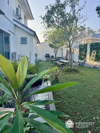 Charming backyard garden with lush greenery and outdoor seating area