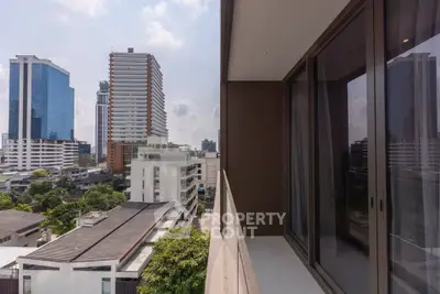 Modern urban balcony with stunning cityscape views and sleek glass doors.