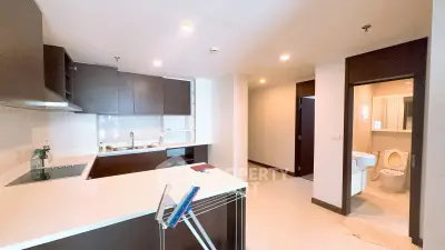 Modern kitchen with sleek cabinetry and adjacent bathroom in a contemporary apartment.