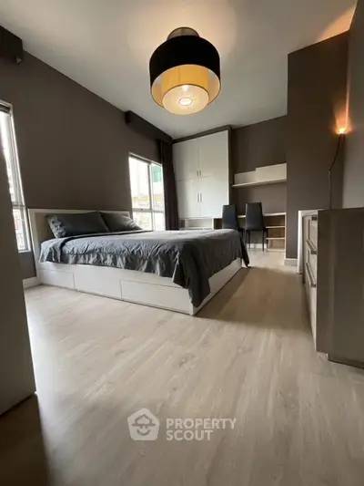 Spacious modern bedroom with stylish decor and ample natural light.