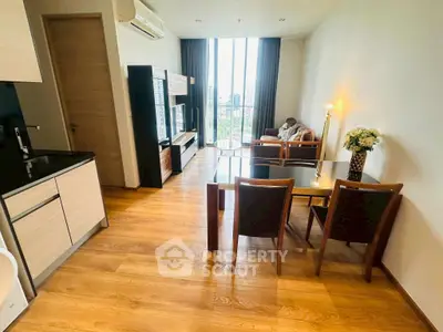 Modern living room with elegant furniture and large window offering city view.