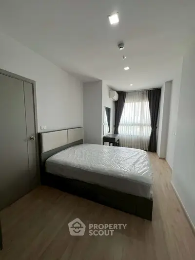 Spacious bedroom with modern design and natural light in a stylish apartment.
