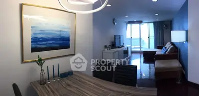 Spacious living room with modern decor and large windows leading to a balcony, perfect for relaxation.