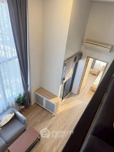 Modern apartment interior with high ceilings and natural light, featuring a cozy living area and stylish bedroom.