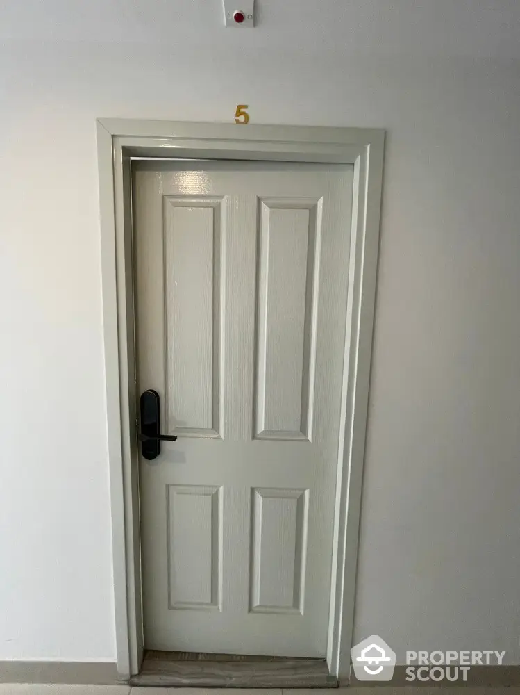 Elegant white door with modern handle in a well-lit hallway, perfect for secure apartment living.