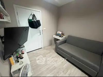 Cozy small living room with modern sofa and wall-mounted TV, perfect for compact urban living.
