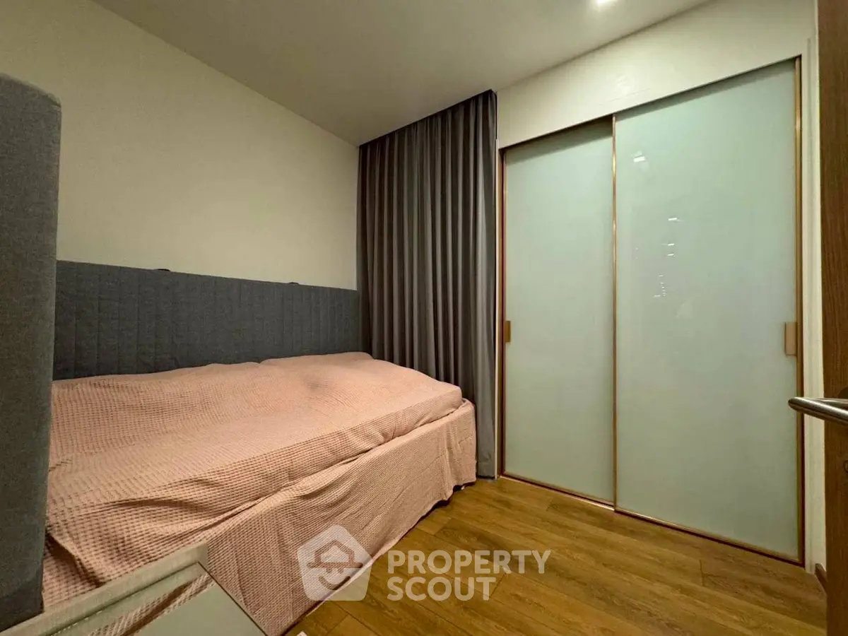 Cozy bedroom with wooden flooring and sliding closet doors