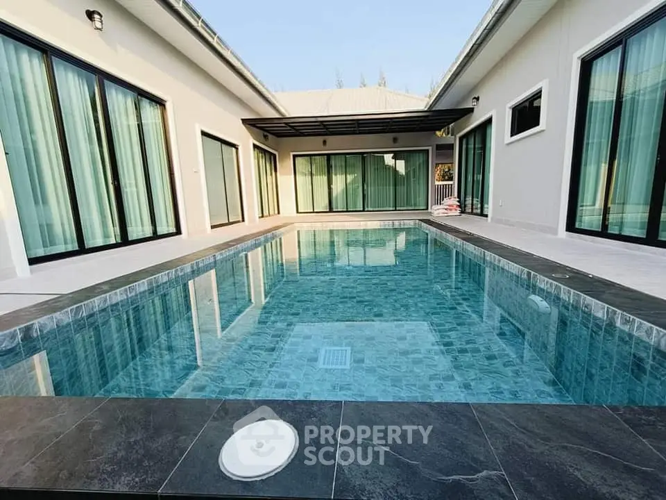 Luxurious modern home with private pool and elegant glass doors, perfect for relaxation and entertainment.