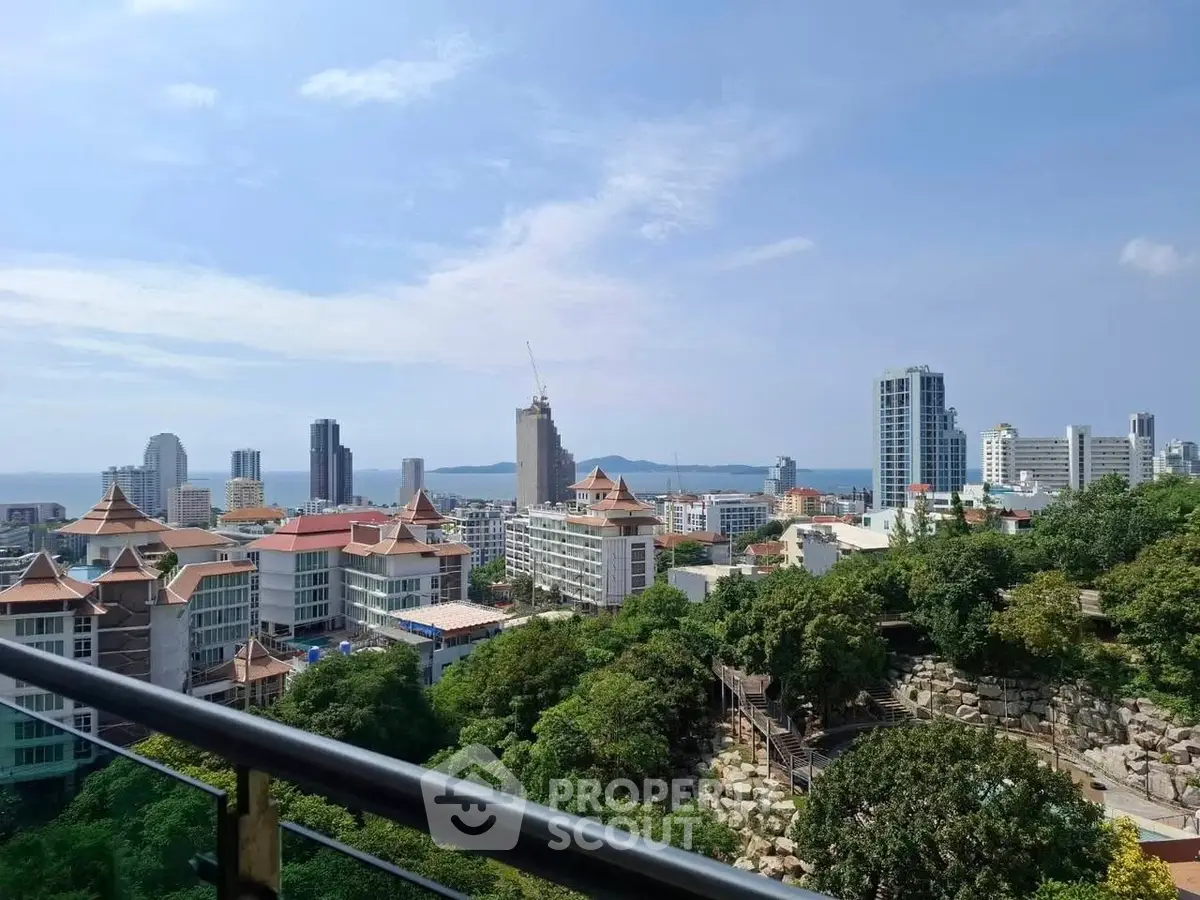 Stunning cityscape view from a high-rise balcony overlooking lush greenery and modern buildings.